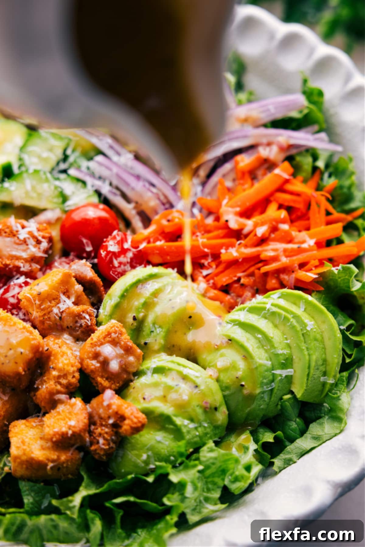 Quick and Easy Garden Salad Recipe Assembly A close-up shot of homemade dressing being drizzled over a vibrant, freshly prepared garden salad in a large bowl, highlighting the enticing textures and colors.