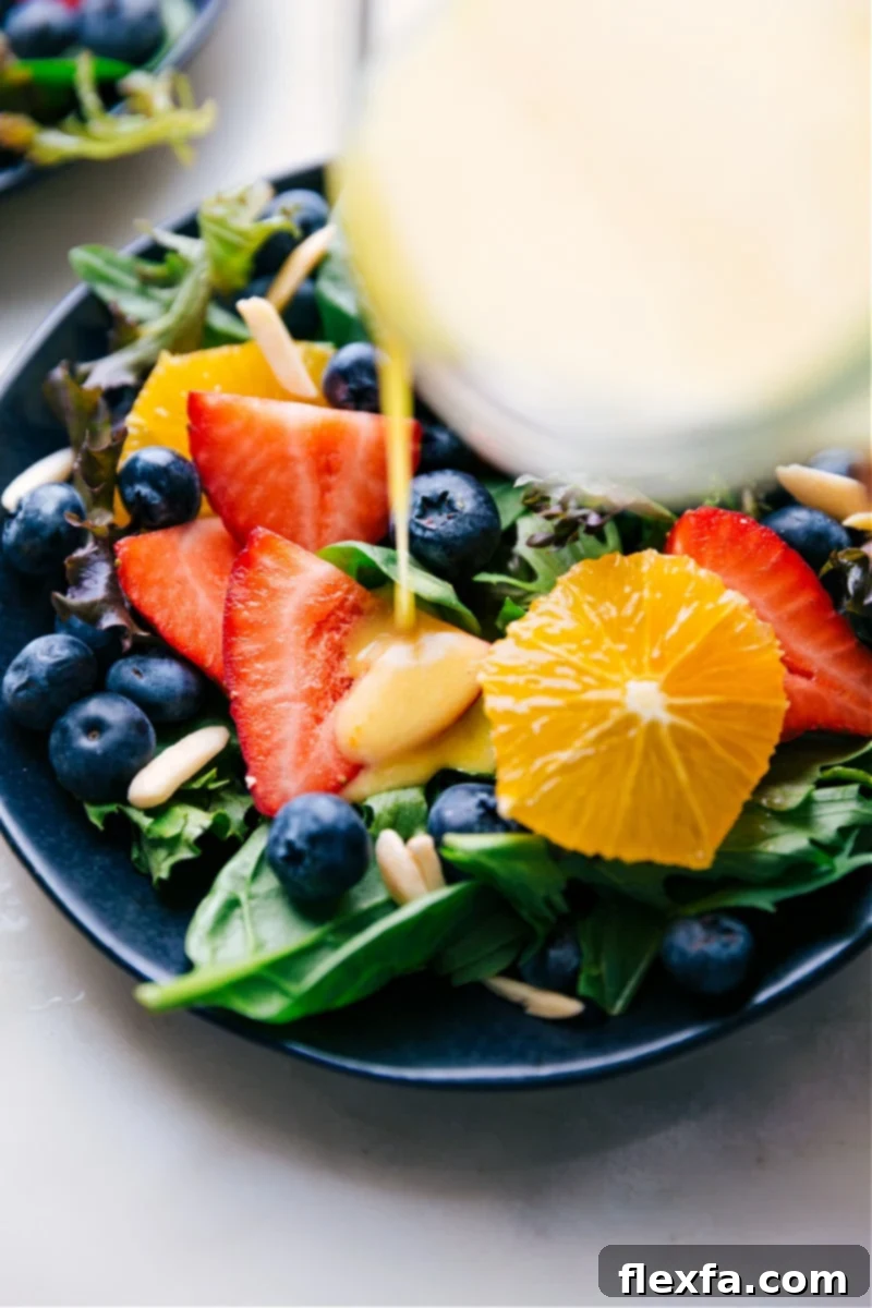 Image of homemade Citrus Vinaigrette being poured generously over a fresh, vibrant salad