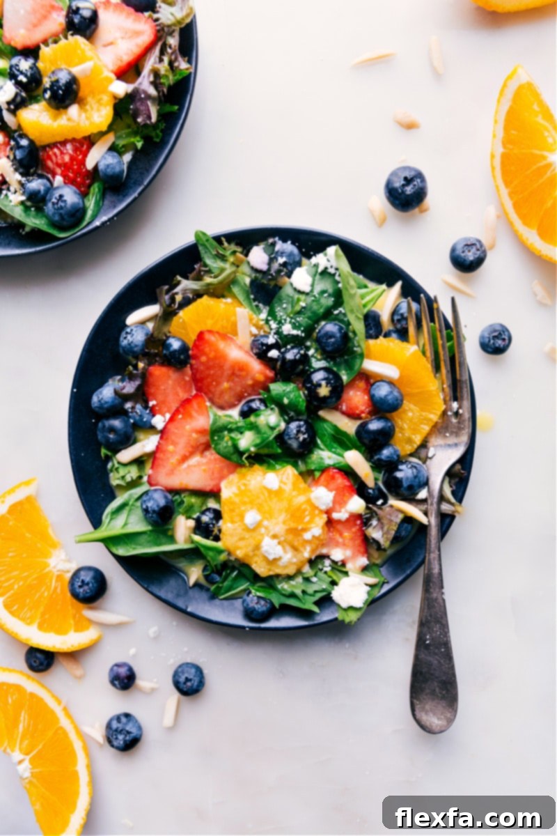 Overhead image of a fully dressed vibrant salad with mixed greens, fruits, and nuts, beautifully adorned with Citrus Vinaigrette.
