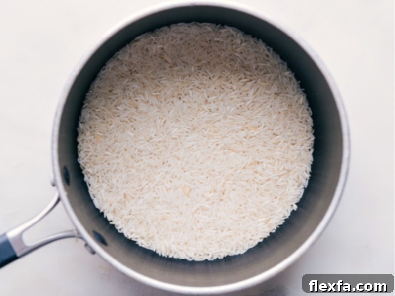 Basmati rice being added to a medium pot, ready for cooking.