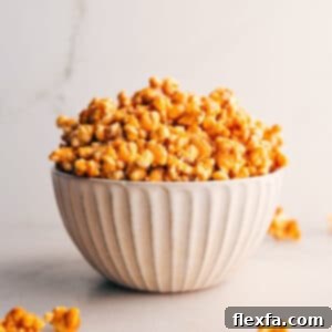 Closeup of homemade caramel corn in a rustic bowl, showcasing its golden, glossy coating.