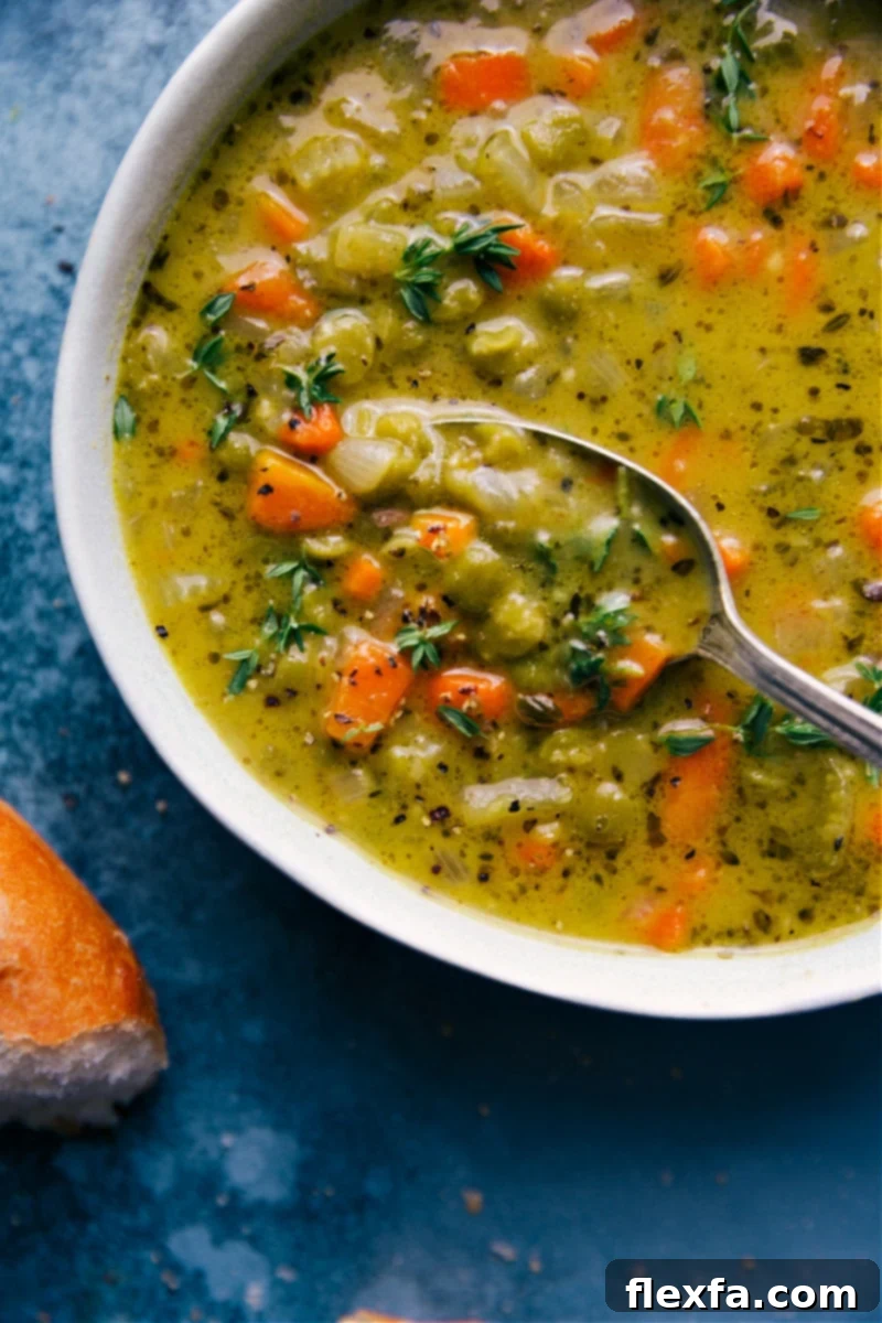 Up-close overhead image of a bowl of Vegetarian Split Pea Soup with a spoonful coming out, showcasing its rich and creamy texture