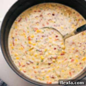 A bowl of Homemade Corn Chowder, rich and creamy, with fresh toppings.