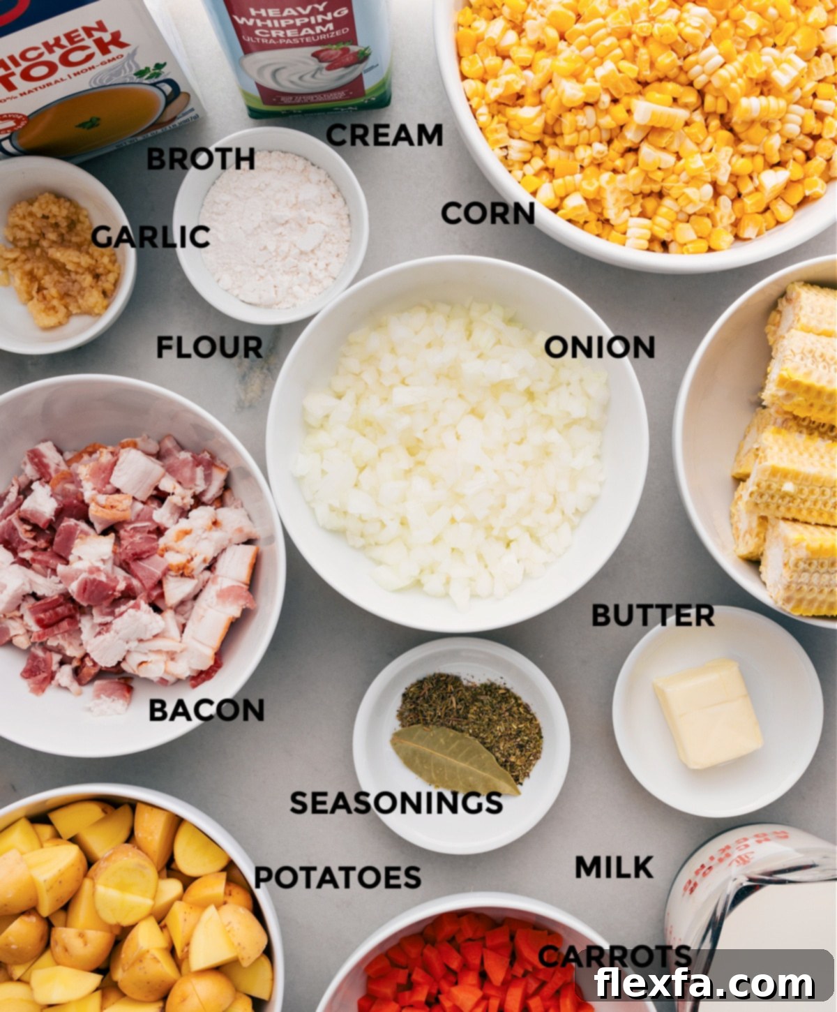 All the fresh ingredients for corn chowder laid out on a cutting board, including corn, bacon, potatoes, and various vegetables.