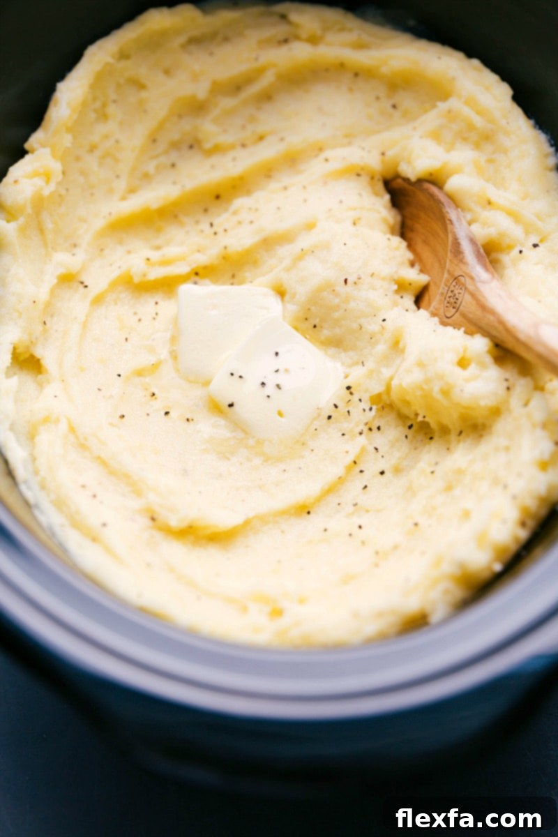 The finished crockpot mashed potato recipe topped with a dollop of butter, ready to be enjoyed.