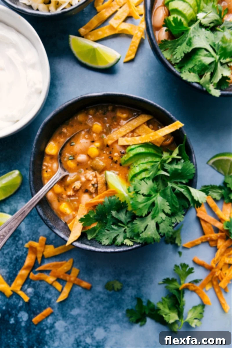 A beautifully presented bowl of White Turkey Chili, garnished with fresh cilantro and lime wedges, ready to be enjoyed.