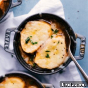 Close-up of French Onion Soup in a crock, topped with melted Gruyere cheese and a golden crouton, ready to be served.