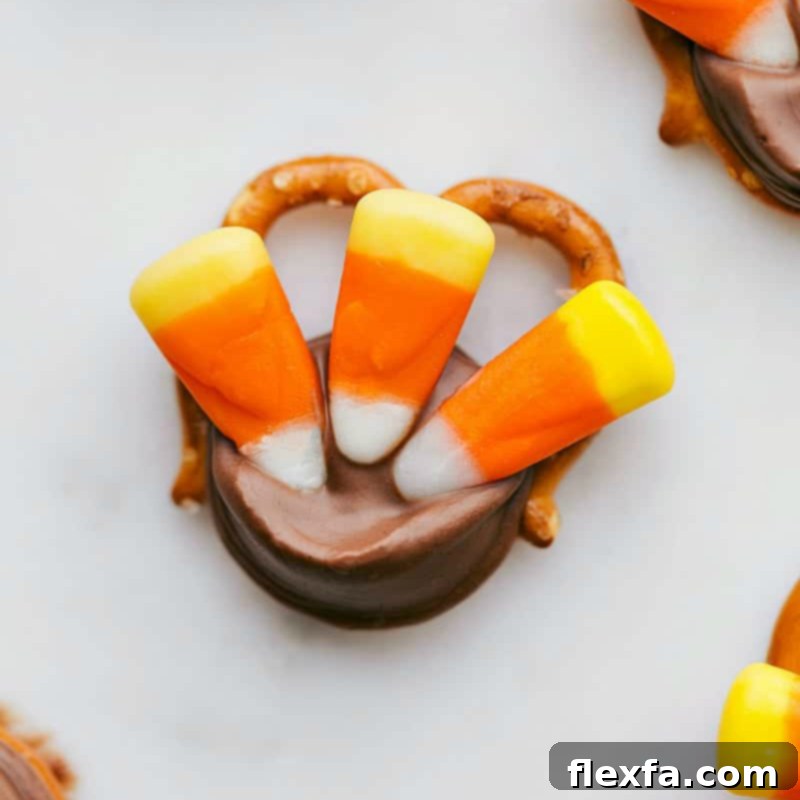 A delightful and colorful turkey pretzel treat, skillfully crafted with candy corn feathers, making a charming and tasty Thanksgiving snack.