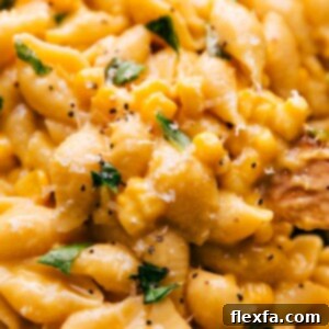 A bowl of creamy corn pasta garnished with fresh basil.