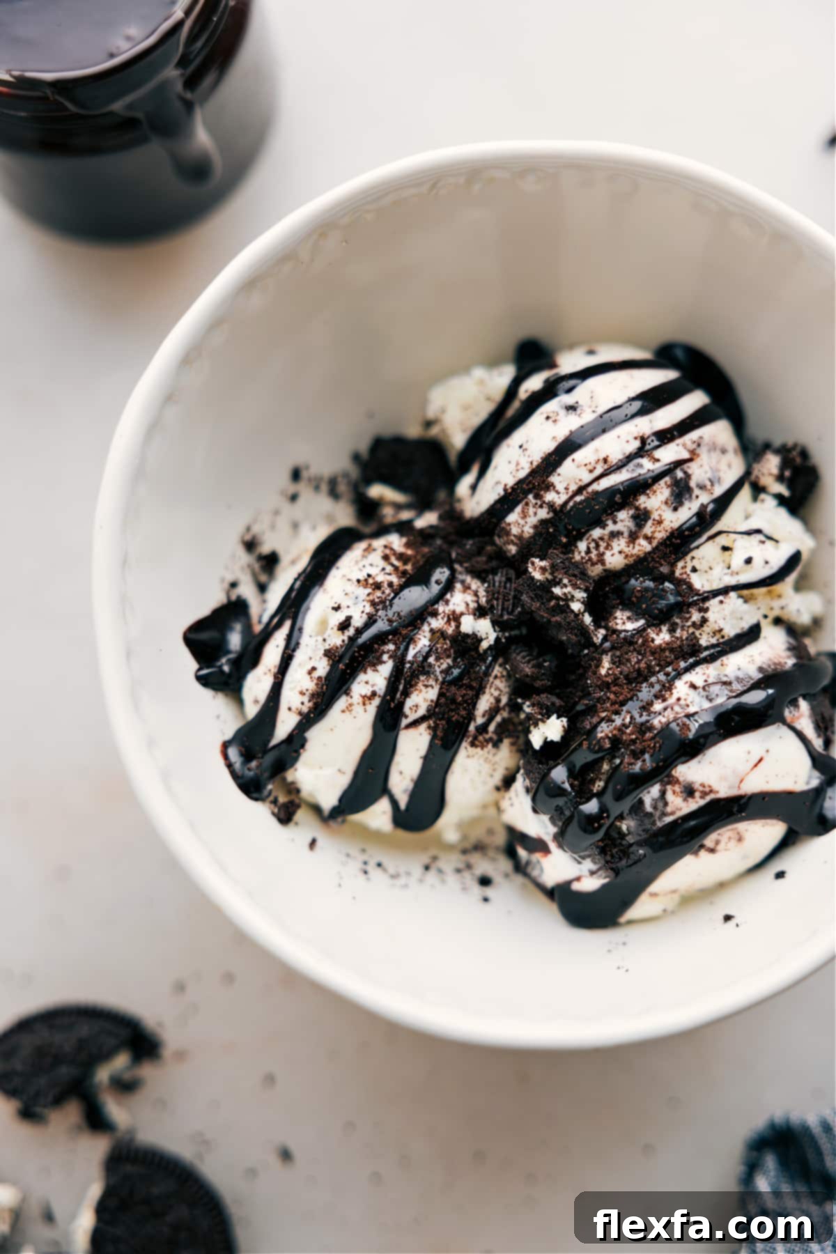 Hot Fudge Sauce drizzles generously over scoops of vanilla ice cream, creating an irresistible dessert.