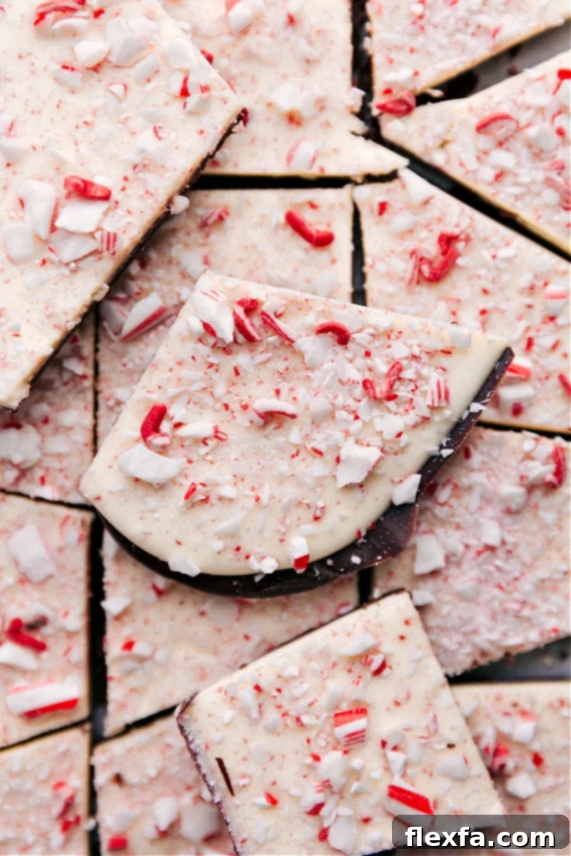 Overhead image of a large slab of Peppermint Bark with three distinct layers of chocolate and crushed candy canes scattered on top.