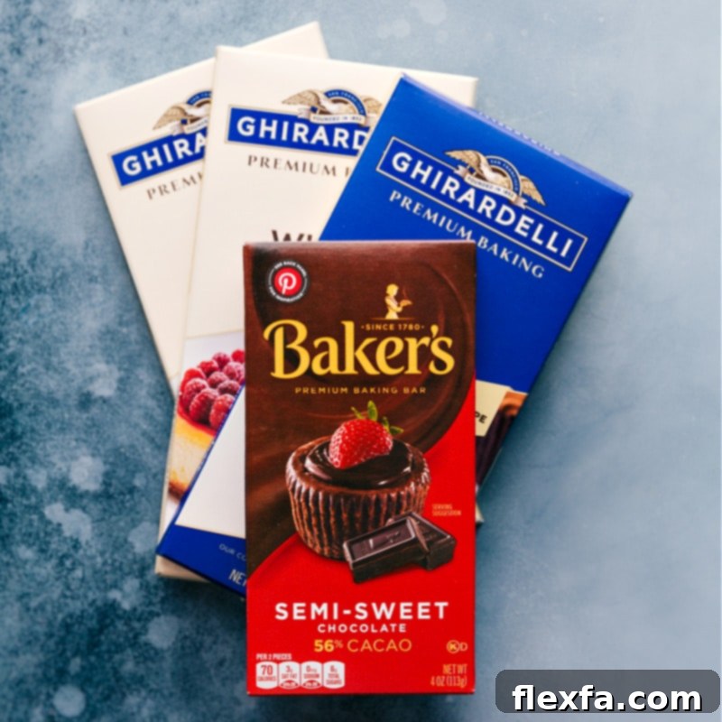 Close-up shot of various chocolate bars including white chocolate, semi-sweet, and milk chocolate, alongside peppermint candies, ready for making bark.
