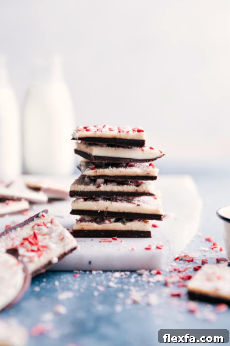Stack of freshly made Peppermint Bark pieces, showcasing the distinct layers of dark and white chocolate with crushed peppermint.