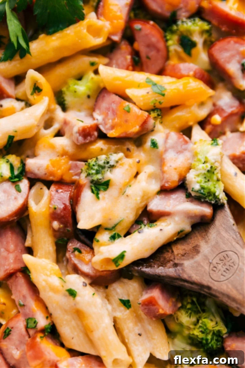 Overhead view of the freshly baked One-Pan Cheesy Sausage Pasta, showing melted cheese, sliced sausage, and tender broccoli.