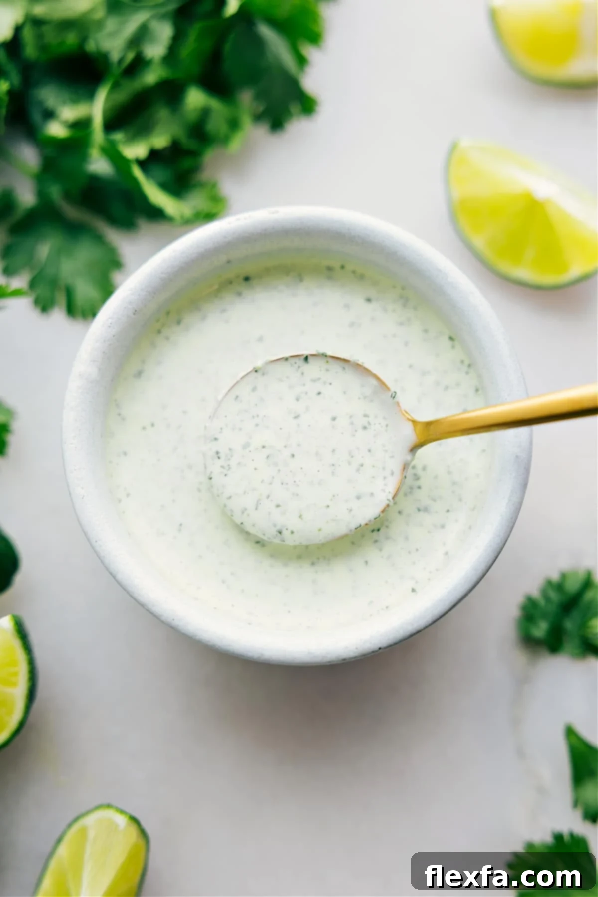 Cilantro Lime Sauce in a bowl with a spoonful coming up.