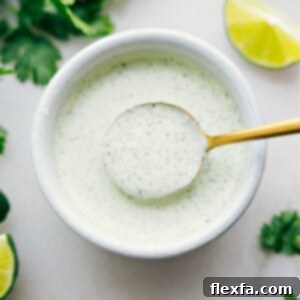 Cilantro Lime Sauce in a bowl with a spoonful coming up.