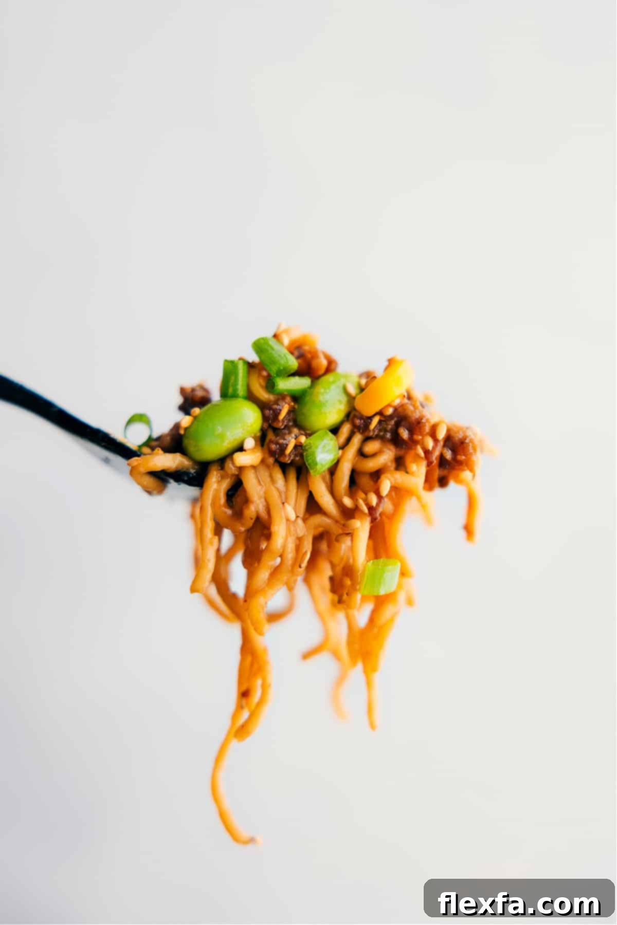 A big forkful of the Pork Ramen Stir Fry Recipe showing all the yummy ingredients and how delicious it looks.