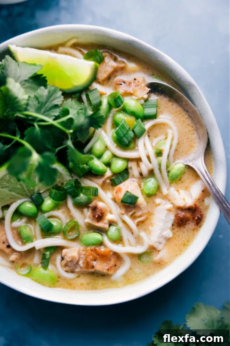 Overhead image of a vibrant bowl of Green Curry Noodle Soup with chicken and noodles visible