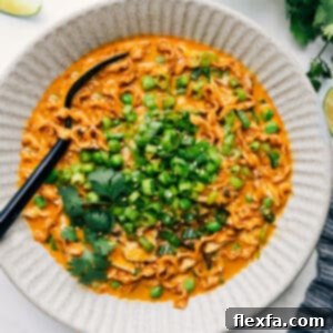 A bowl of delicious Red Curry Noodle Soup with chicken and herbs.