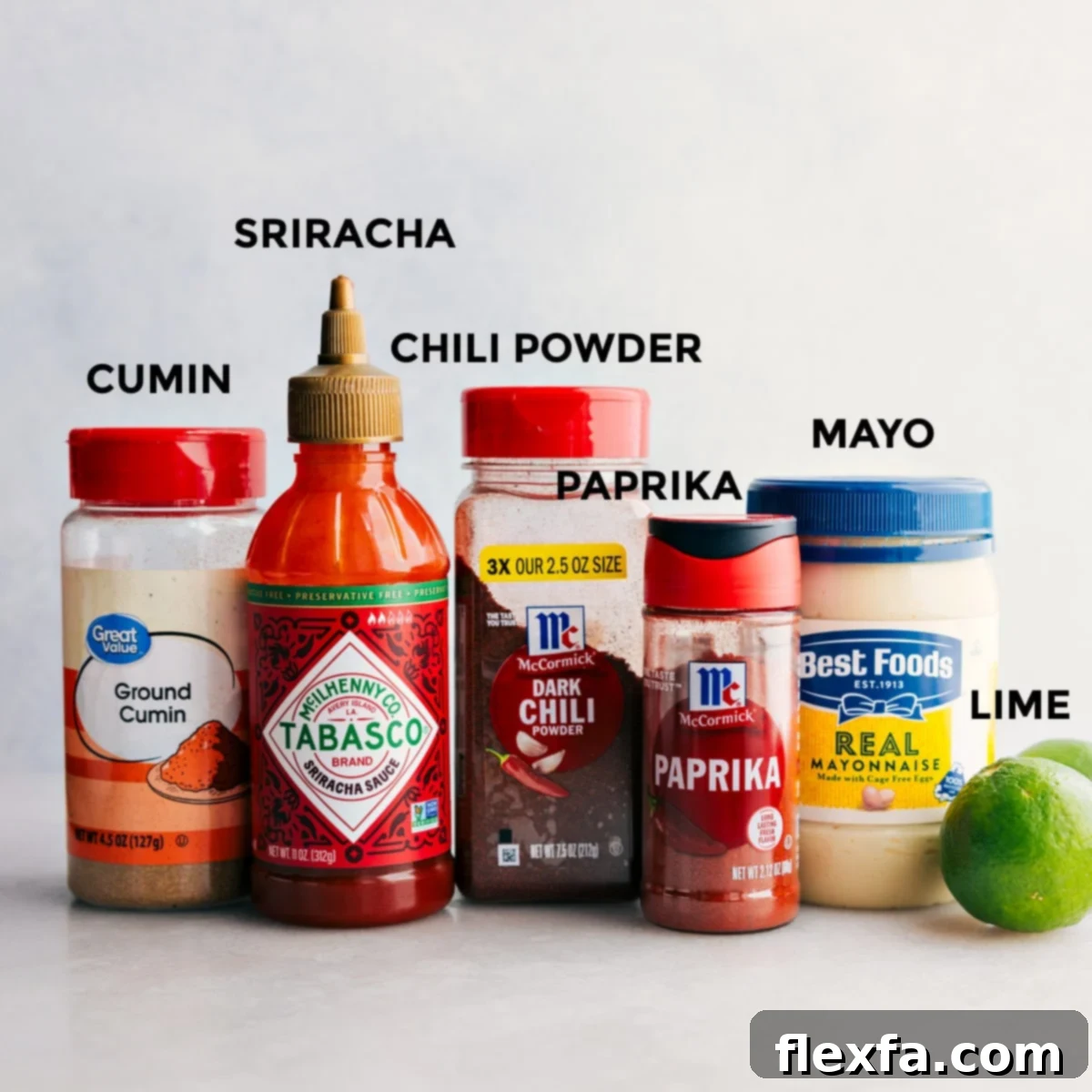 All the dressing ingredients including cumin, sriracha, chili powder, paprika, mayo, and limes prepped out for easy assembly.