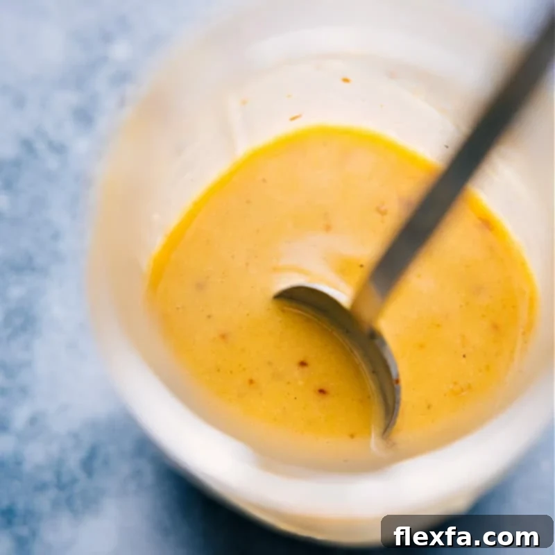 The Star of the Show: Close-up of the Irresistible Hot Honey Mustard Sauce, Perfect for Elevating Your Nourish Bowl. Overhead image of a small bowl filled with the homemade hot honey mustard sauce, illustrating its smooth texture and rich color.
