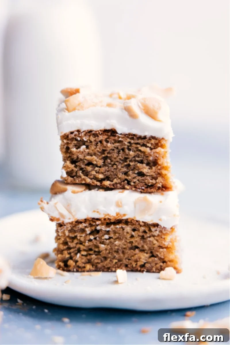 Image of two slices of Cashew Cake stacked on top of each other, showcasing its dense texture and creamy frosting