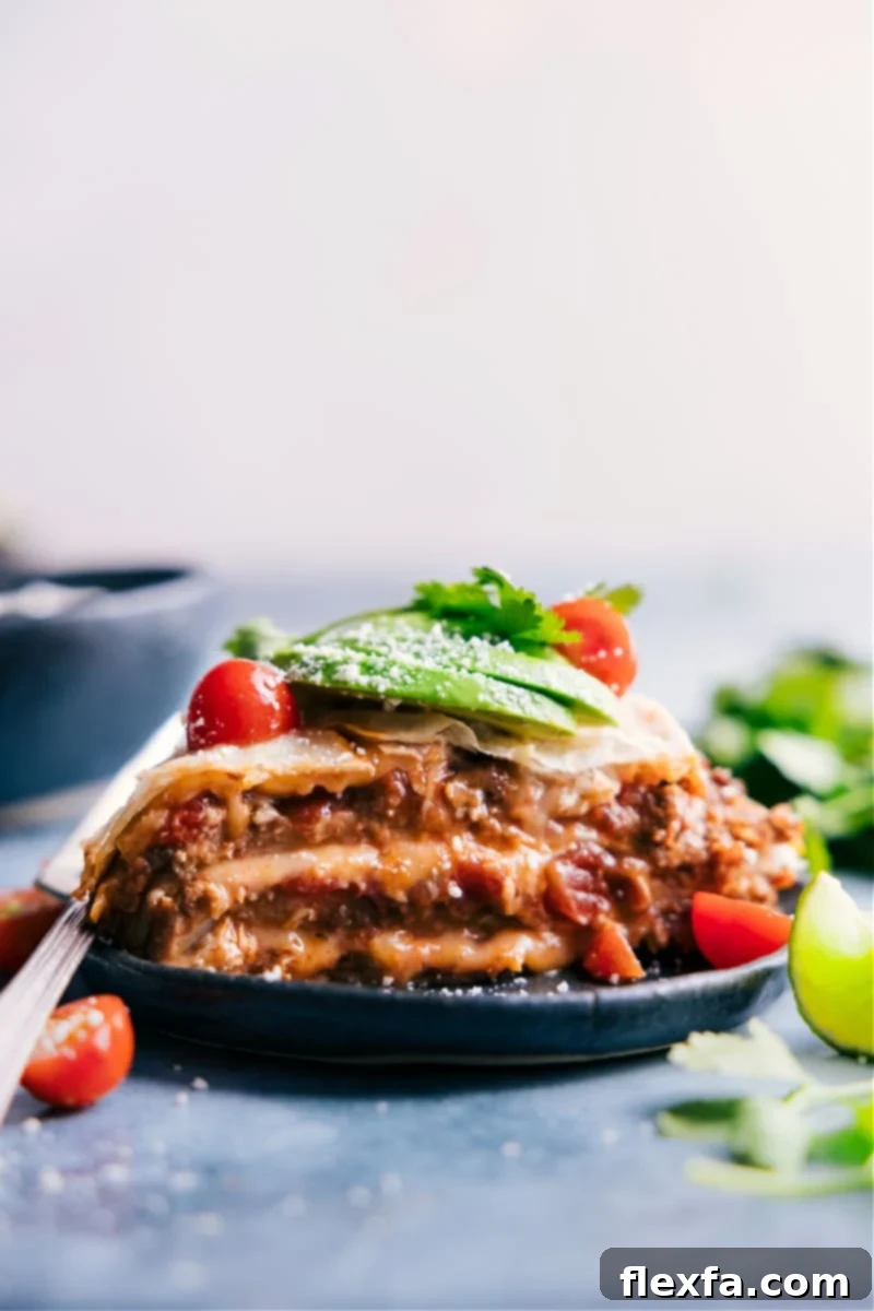 A delicious slice of Tortilla Pie on a plate, showcasing its beautiful layers of beef, beans, salsa, and cheese.