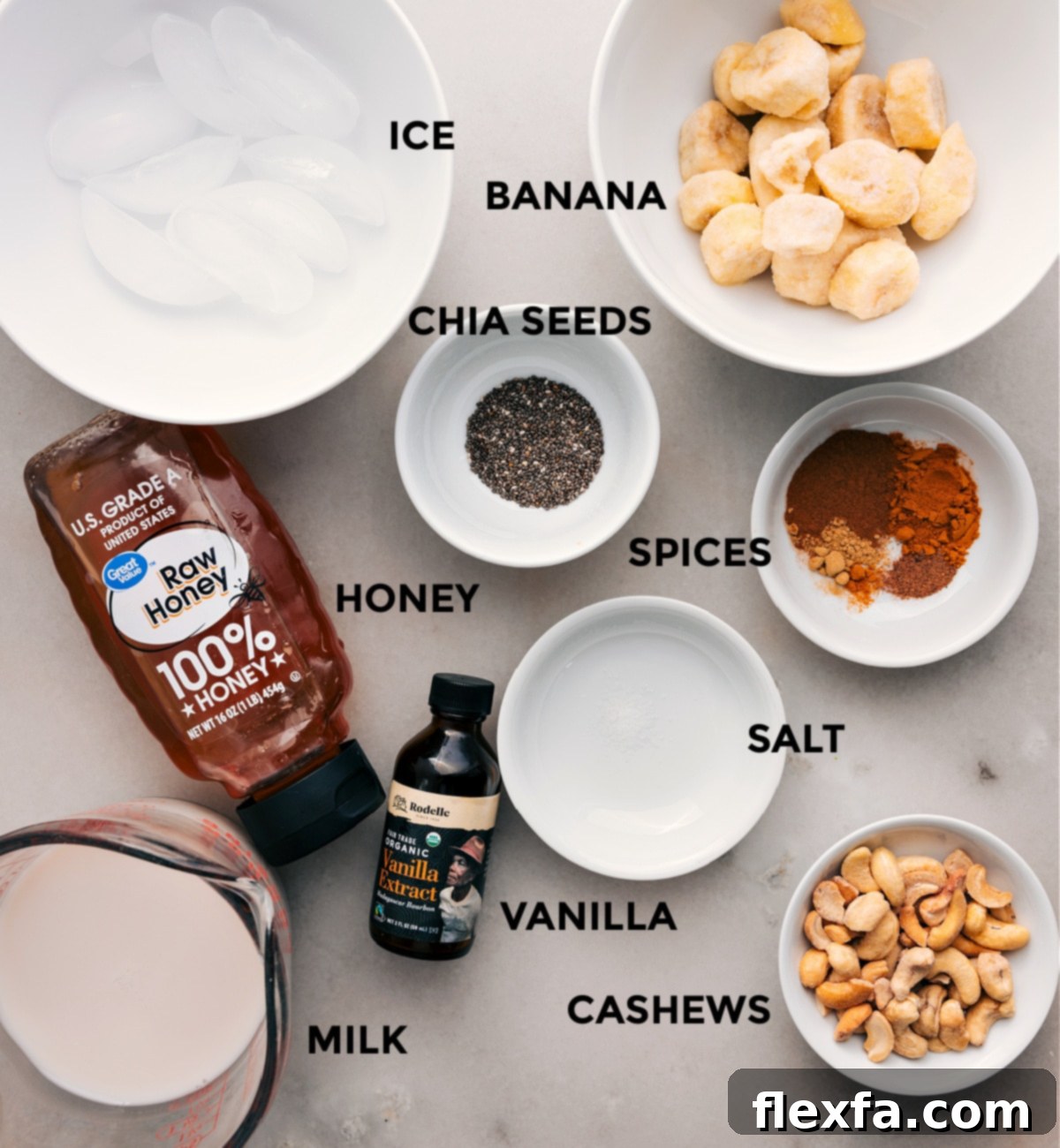 Essential Ingredients for Your Healthy Golden Milk Smoothie All the prepped ingredients for the Golden Milk Smoothie laid out: sliced frozen bananas, ice, various spices in small bowls, a jar of honey, cashews, vanilla extract, and a bottle of plant-based milk.