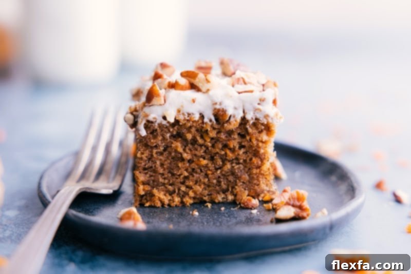 Close-up image of a perfectly baked and frosted Gluten-Free Carrot Cake slice on a white plate, ready to be enjoyed.