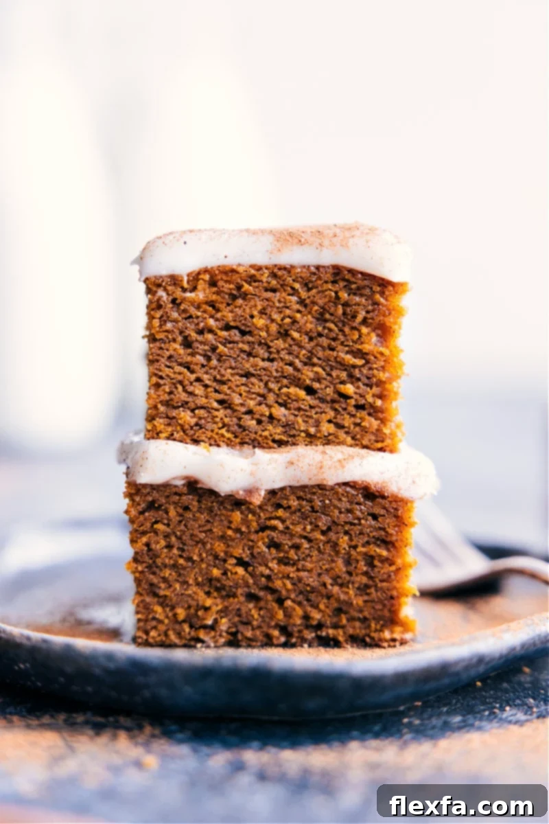 Close-up of three slices of moist, healthy pumpkin cake stacked with a dusting of powdered sugar.
