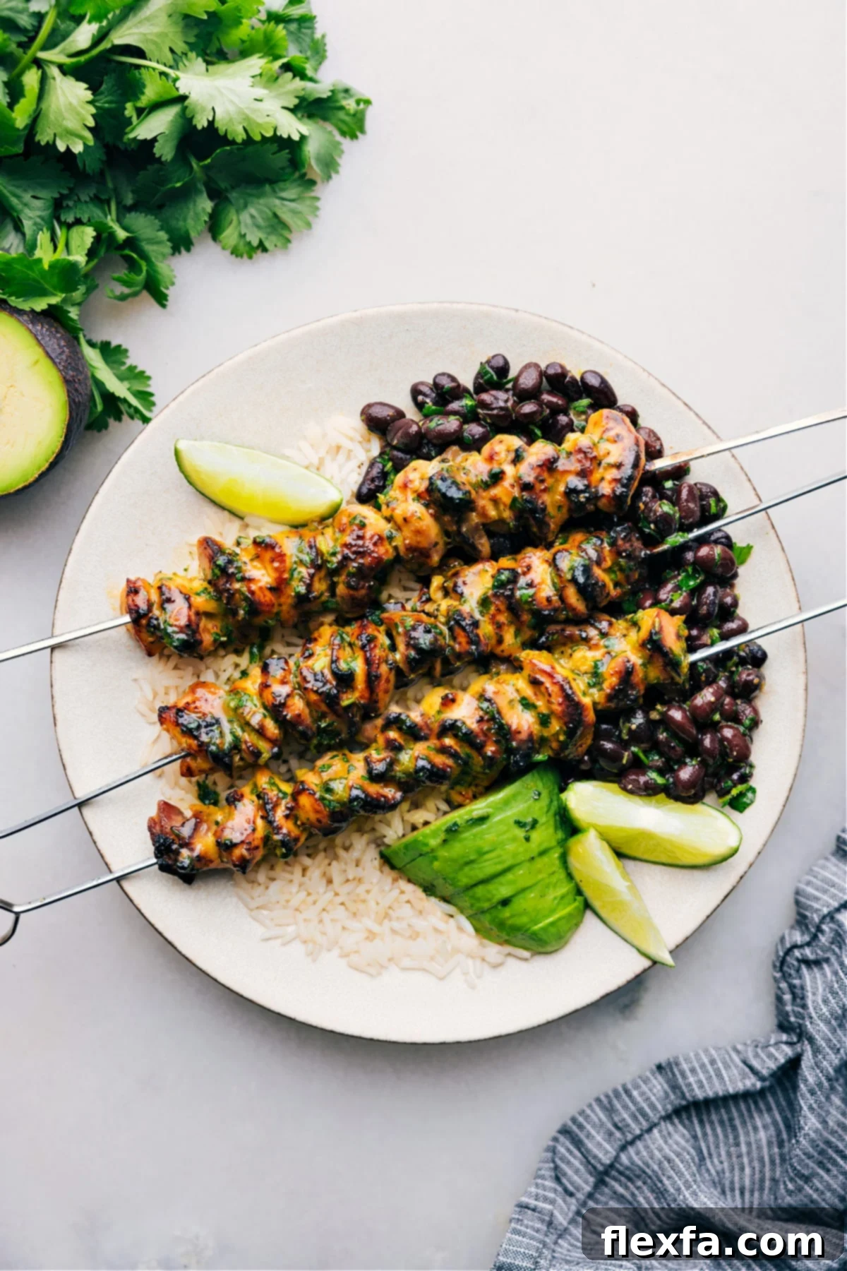 The Best Citrus Chicken Marinade A plate of perfectly cooked citrus chicken over rice, garnished with fresh cilantro.