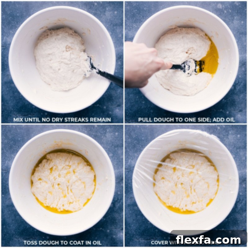 Bowl with flour, water, yeast, and honey mixed into a shaggy dough, then olive oil being poured over it, covered with plastic wrap.