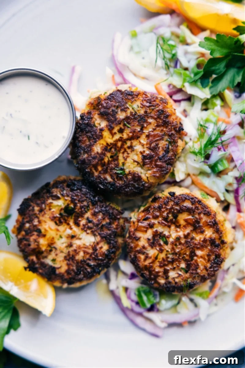 Crispy Tuna Cakes 2 Overhead view of perfectly golden-brown tuna patties served with a side of coleslaw and a bowl of tartar sauce