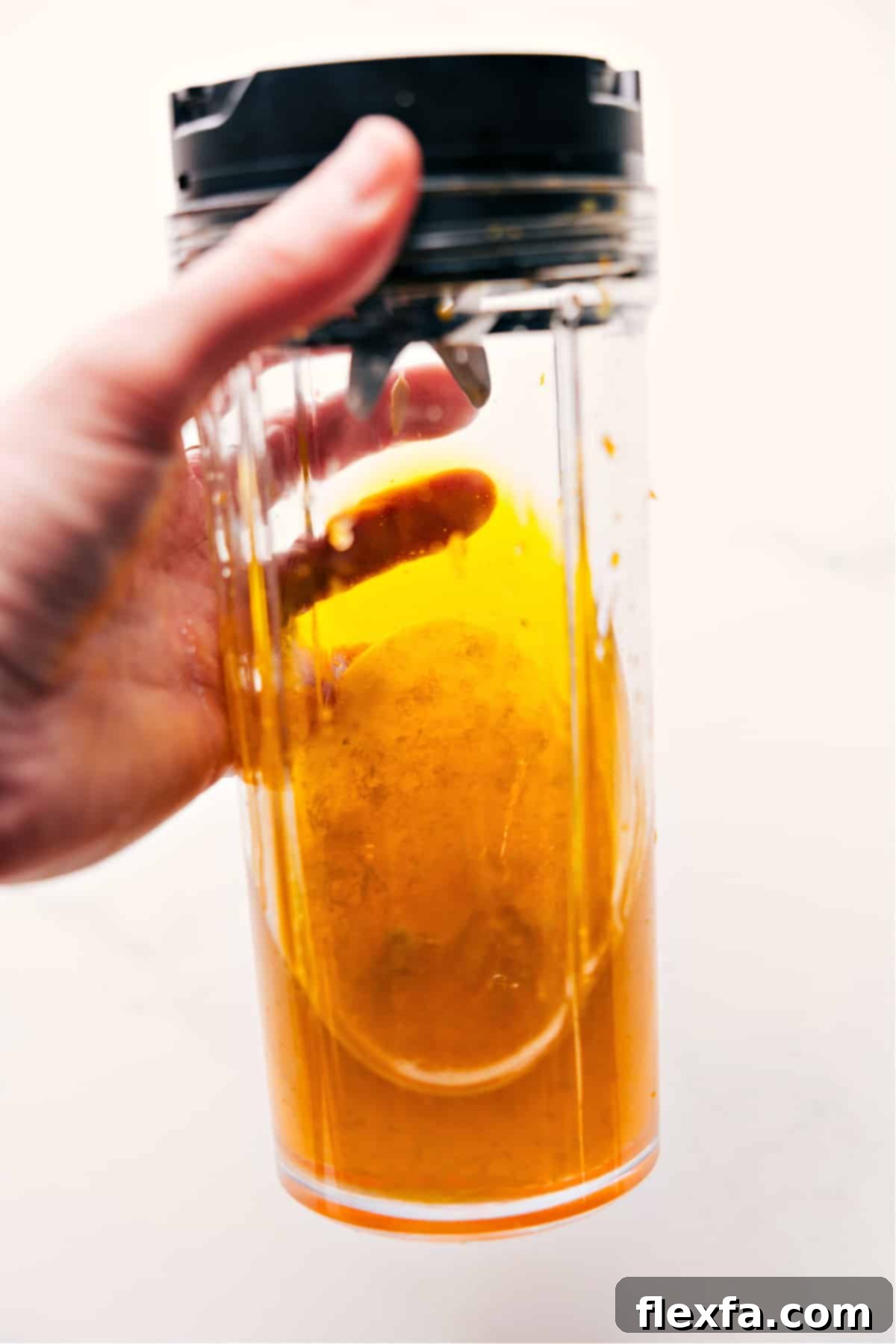 All the citrus dressing ingredients are combined in a blender and pulsed until a smooth, perfectly emulsified vinaigrette is formed, ready to complement the fresh peach salad.
