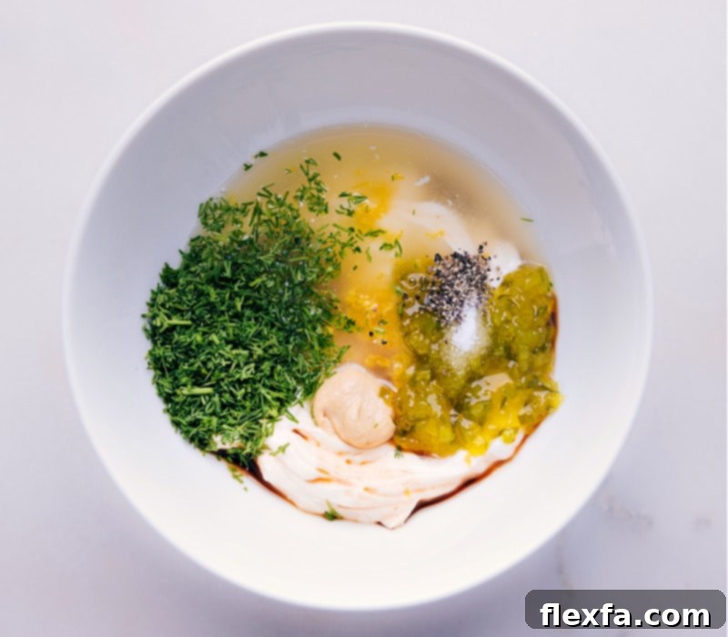 All the delicious ingredients mixed together for our tangy, zesty, and fresh Tartar Sauce recipe. Ready to chill and elevate your favorite seafood dishes. Another process shot showing all the ingredients for Tartar Sauce fully combined in a bowl, ready to be chilled.