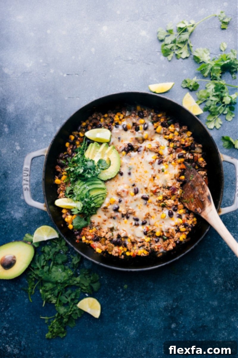 Overhead image of the Green Chile Ground Turkey skillet, garnished with fresh cilantro and a lime wedge