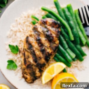 Italian Chicken Marinade recipe on a plate over a bed of rice with green beans. A vibrant and healthy meal.