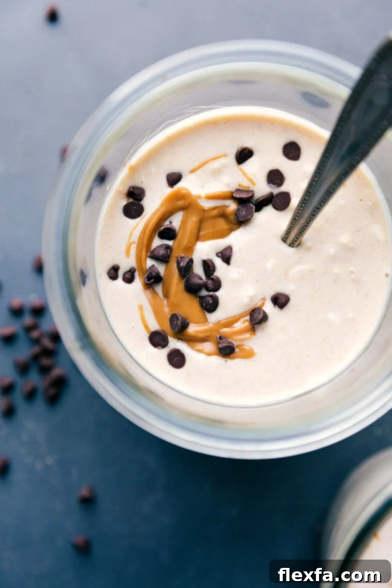 Finished peanut butter cheesecake overnight oats, adorned with a gorgeous peanut butter swirl and mini chocolate chips on top, ready to be enjoyed.