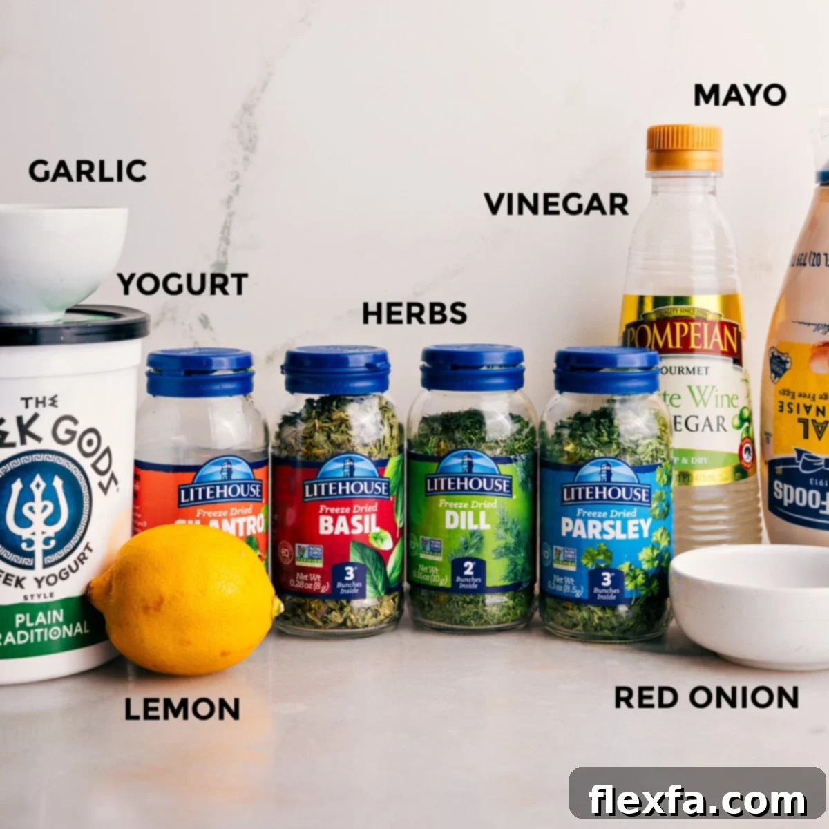 All the vibrant ingredients for this green goddess dressing recipe are prepped and ready for easy assembly: creamy mayo, tangy vinegar, a blend of fresh herbs, rich Greek yogurt, and aromatic garlic.