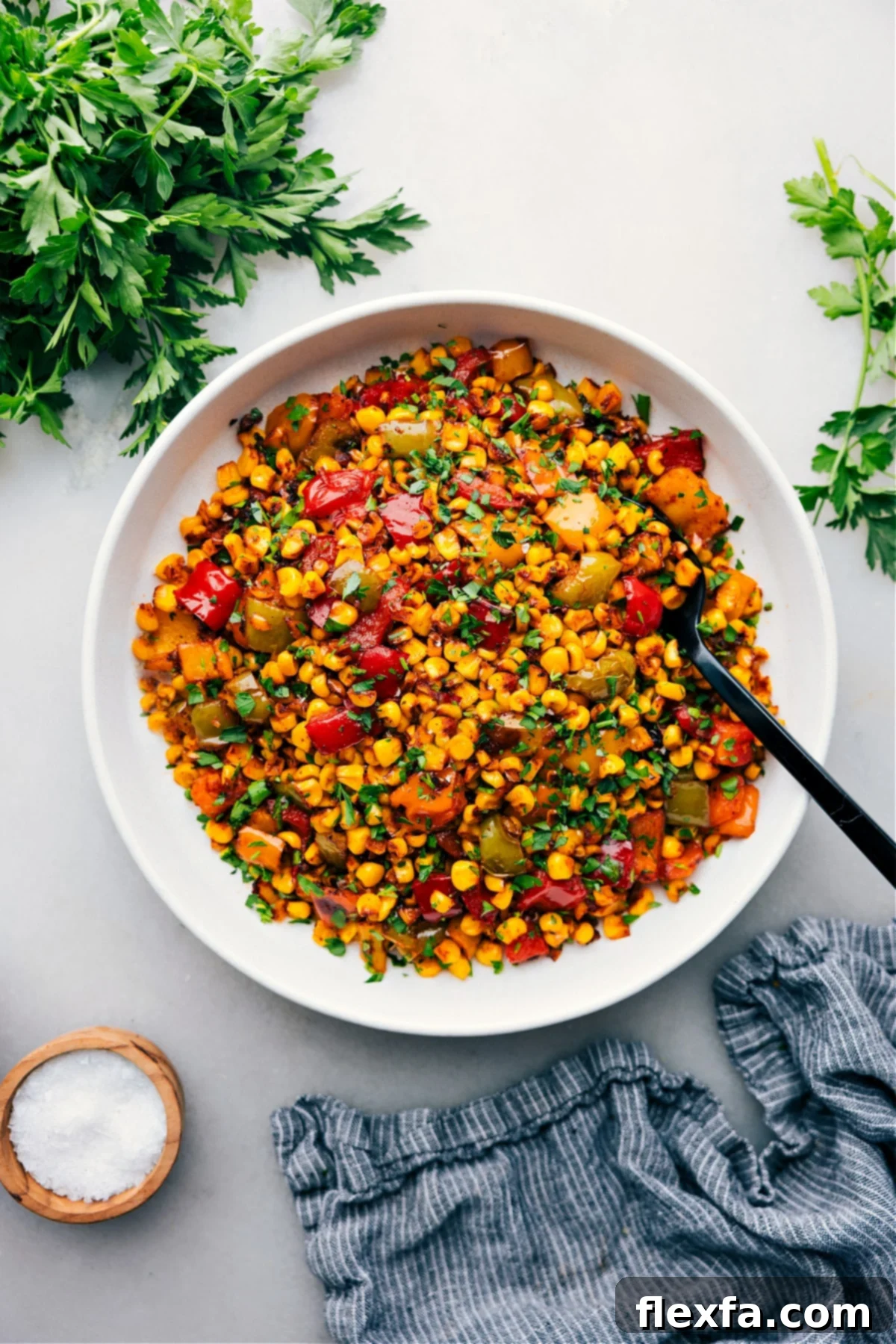 A bowl of freshly roasted corn with colorful sweet peppers, ready to be served at a summer BBQ or family dinner.