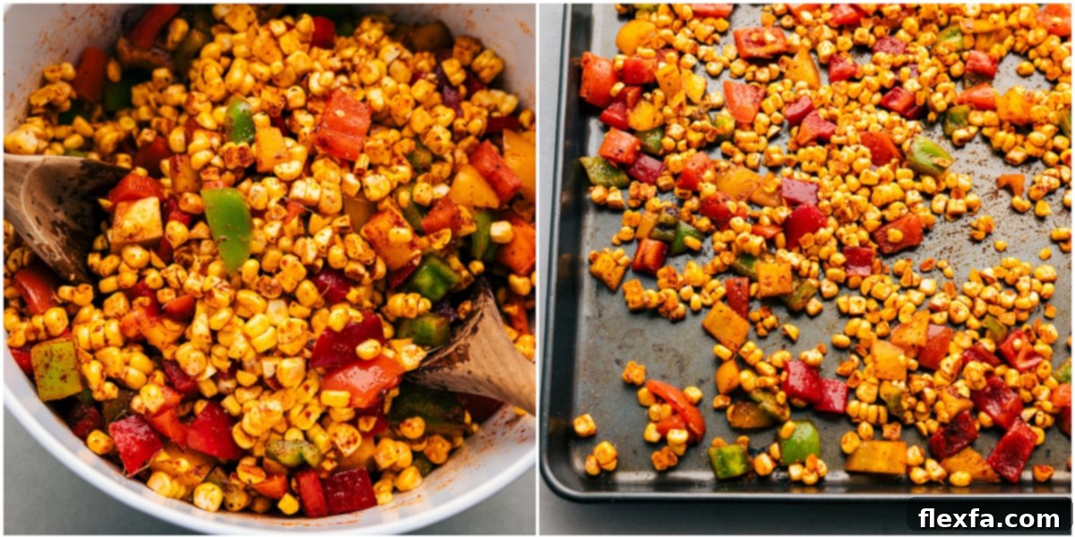 Corn kernels and diced bell peppers tossed with olive oil and seasonings, spread evenly on a sheet pan, ready for roasting.