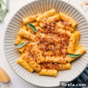 Delicious bowl of creamy pumpkin pasta with crispy sage topping, ready to be enjoyed.