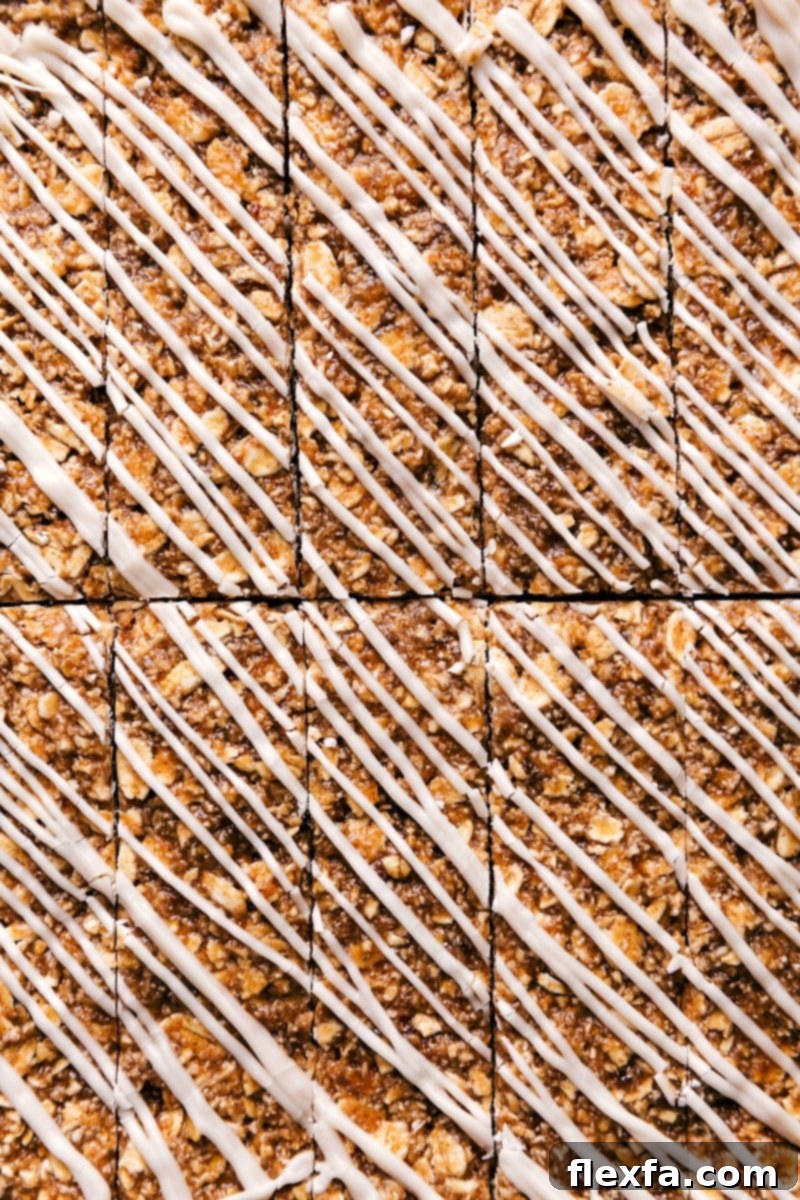 Delicious No-Bake Iced Oatmeal Granola Bars stacked with a sweet white chocolate glaze