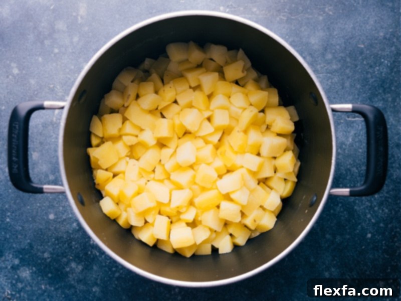 Overhead view looking into the pot, showing the perfectly cooked potato cubes, ready to be coated in the creamy sauce.