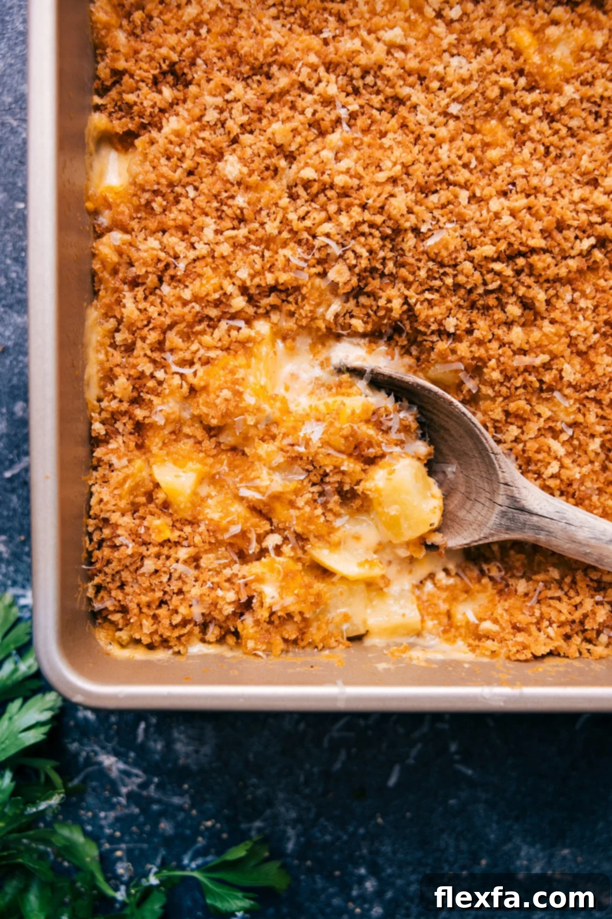 Freshly baked Cheesy Potatoes with a big scoop ready to serve!