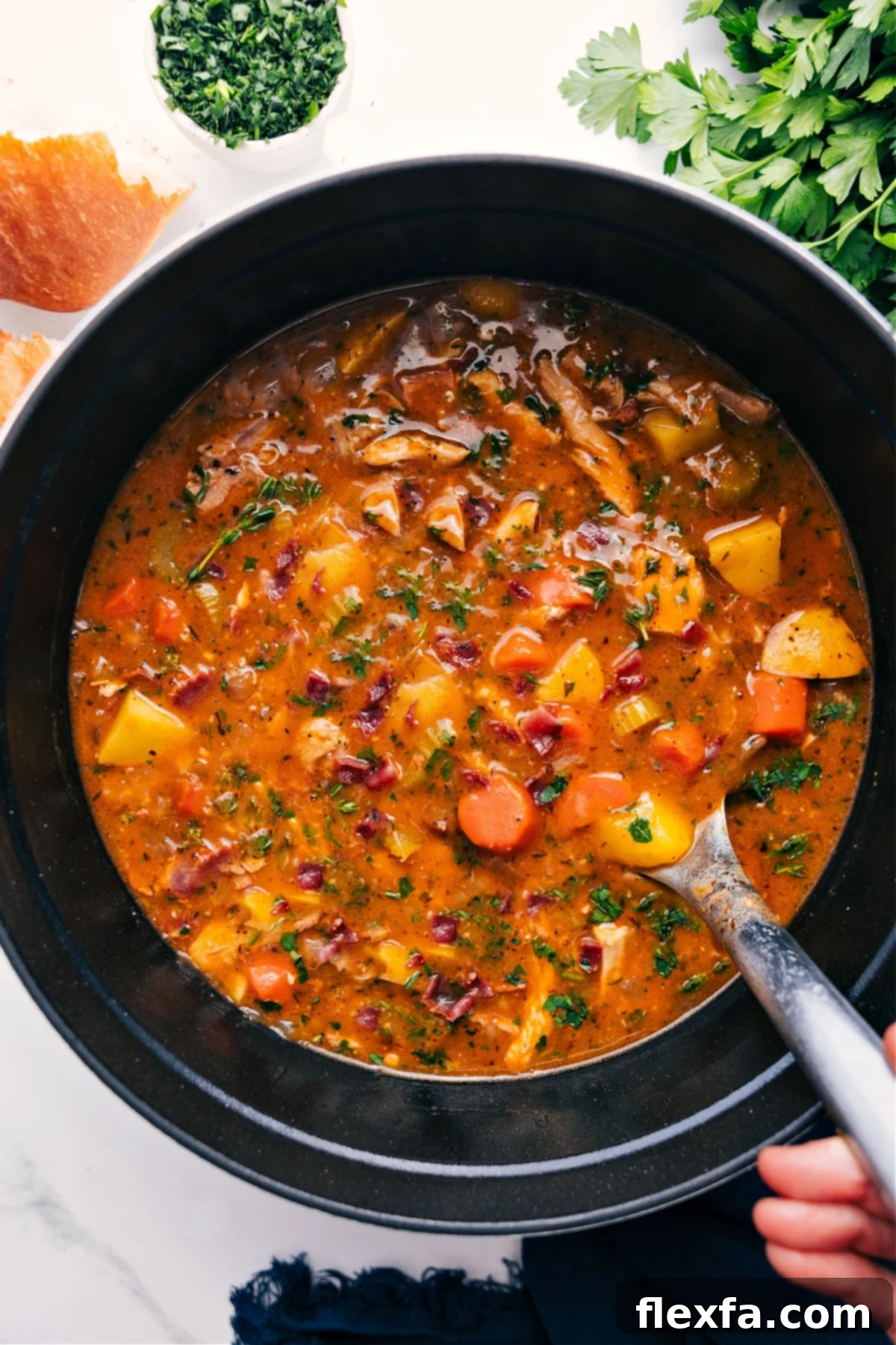 A rustic cast-iron pot brimming with homemade chicken stew, featuring tender chicken pieces, vibrant carrots, golden potatoes, and rich brown gravy, garnished with fresh herbs, ready to be served.