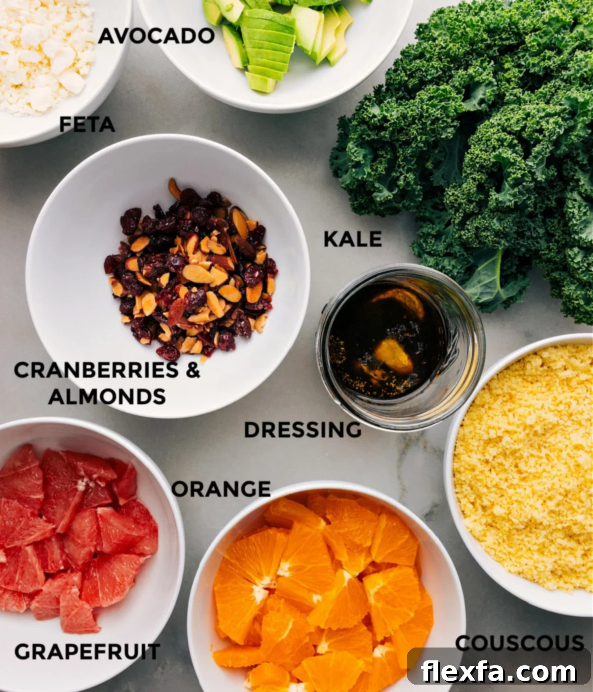 All the fresh ingredients for the Grapefruit Salad recipe, meticulously prepped and arranged for easy assembly, including kale, grapefruit, oranges, avocado, and almonds.
