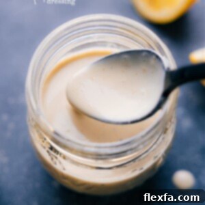 Close-up of creamy tahini dressing in a bowl, garnished with fresh herbs