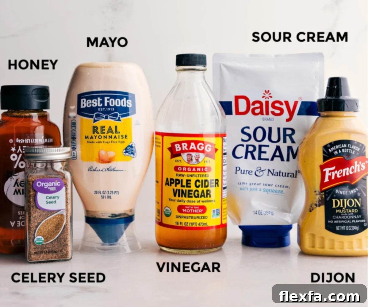 All the dressing ingredients for the apple coleslaw dressing including mayonnaise, sour cream, apple cider vinegar, Dijon mustard, honey, and seasonings, prepped out for easy assembly.