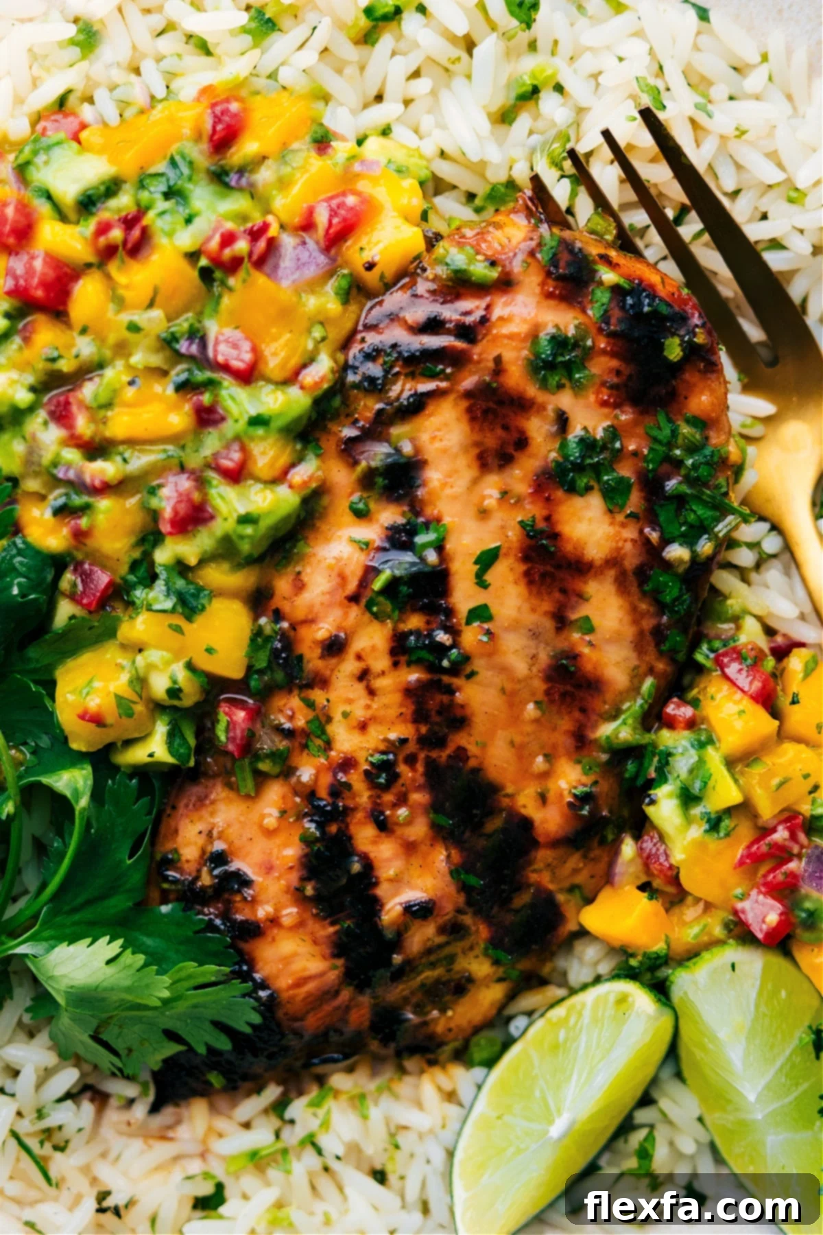 The final plating of Cilantro Lime Chicken, elegantly presented on a bed of rice and generously topped with vibrant mango avocado salsa, ready for enjoyment.